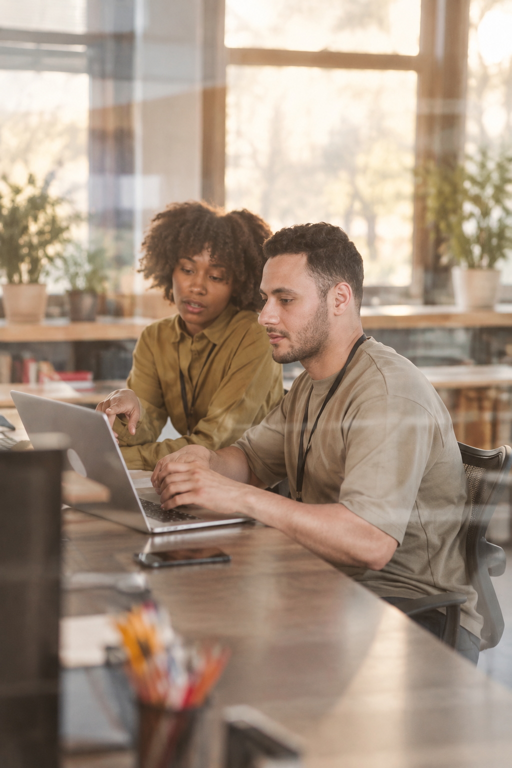 Two teammates working together at a laptop